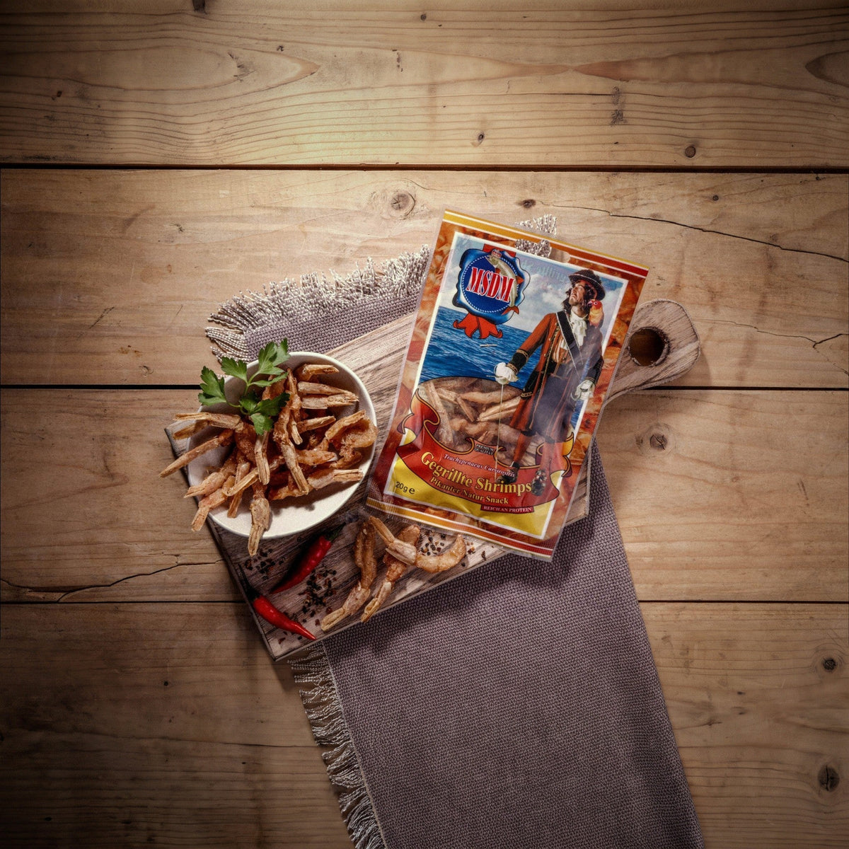 Gegrillte Shrimps Pikant – Packung und Snack auf dem Holztisch