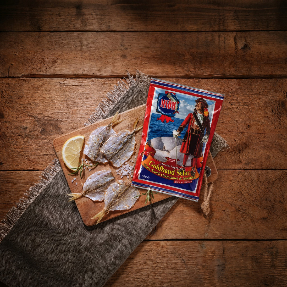 Goldband Selar Original – Packung und Trockenfisch auf dem Holztisch