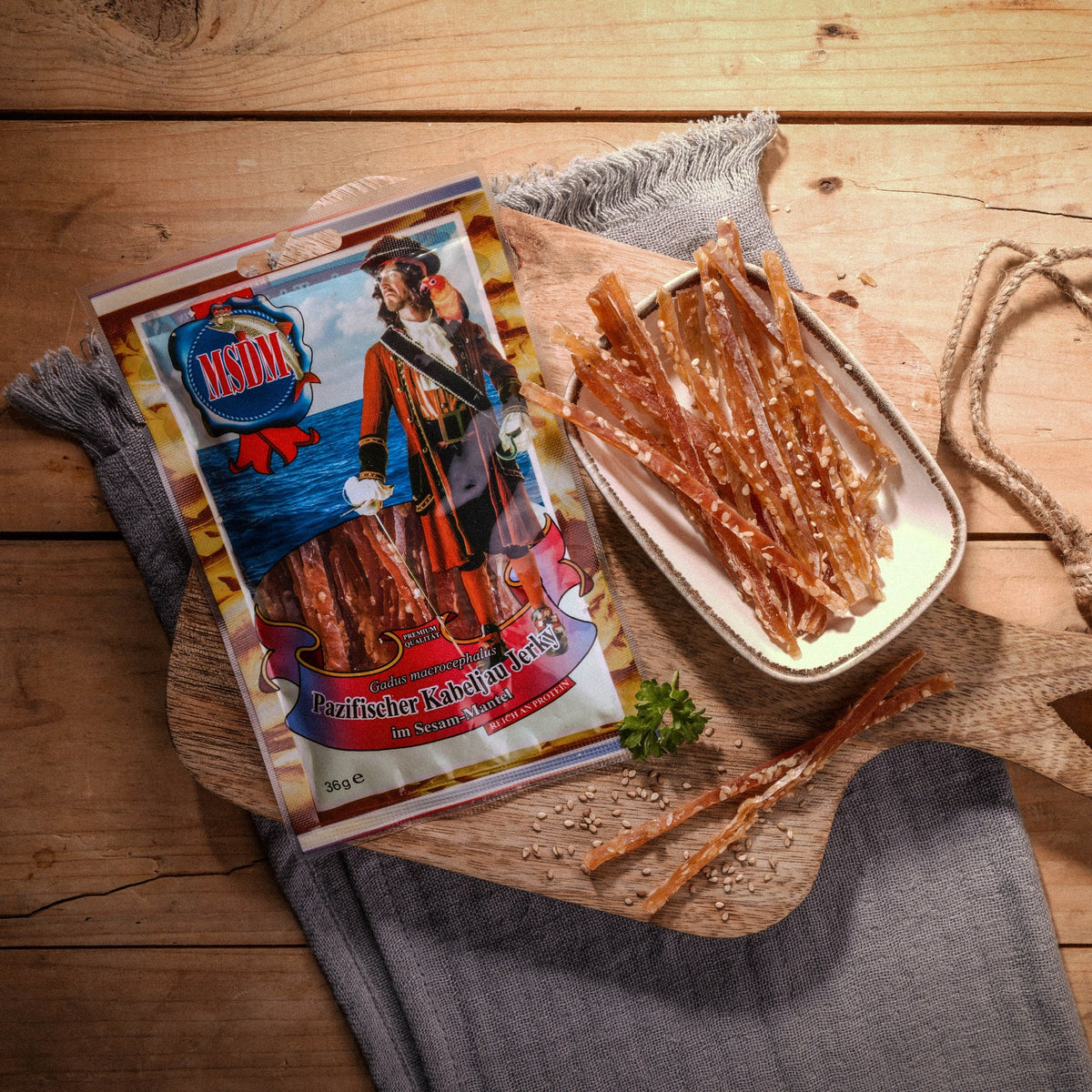 Kabeljau Jerky mit Sesam – Packung und Snack auf dem Holztisch