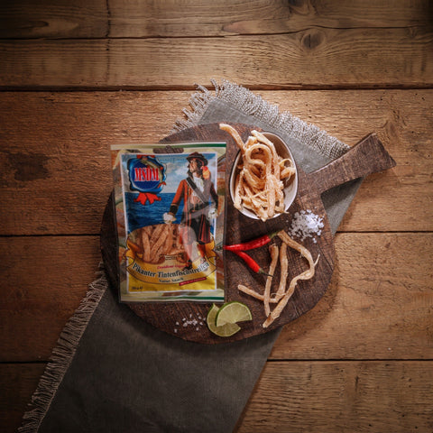 Pikante Tintenfischstreifen – Packung und Snack auf dem Holztisch