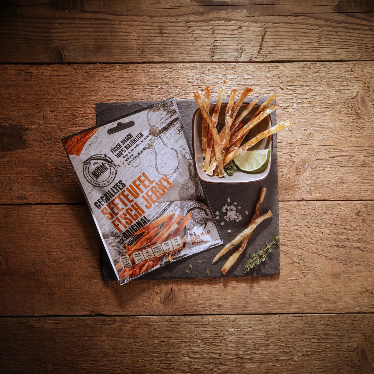Gegrilltes Seeteufel Fisch Jerky – Packung und Snack auf dem Holztisch