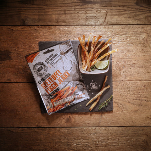 Gegrilltes Seeteufel Fisch Jerky – Packung und Snack auf dem Holztisch