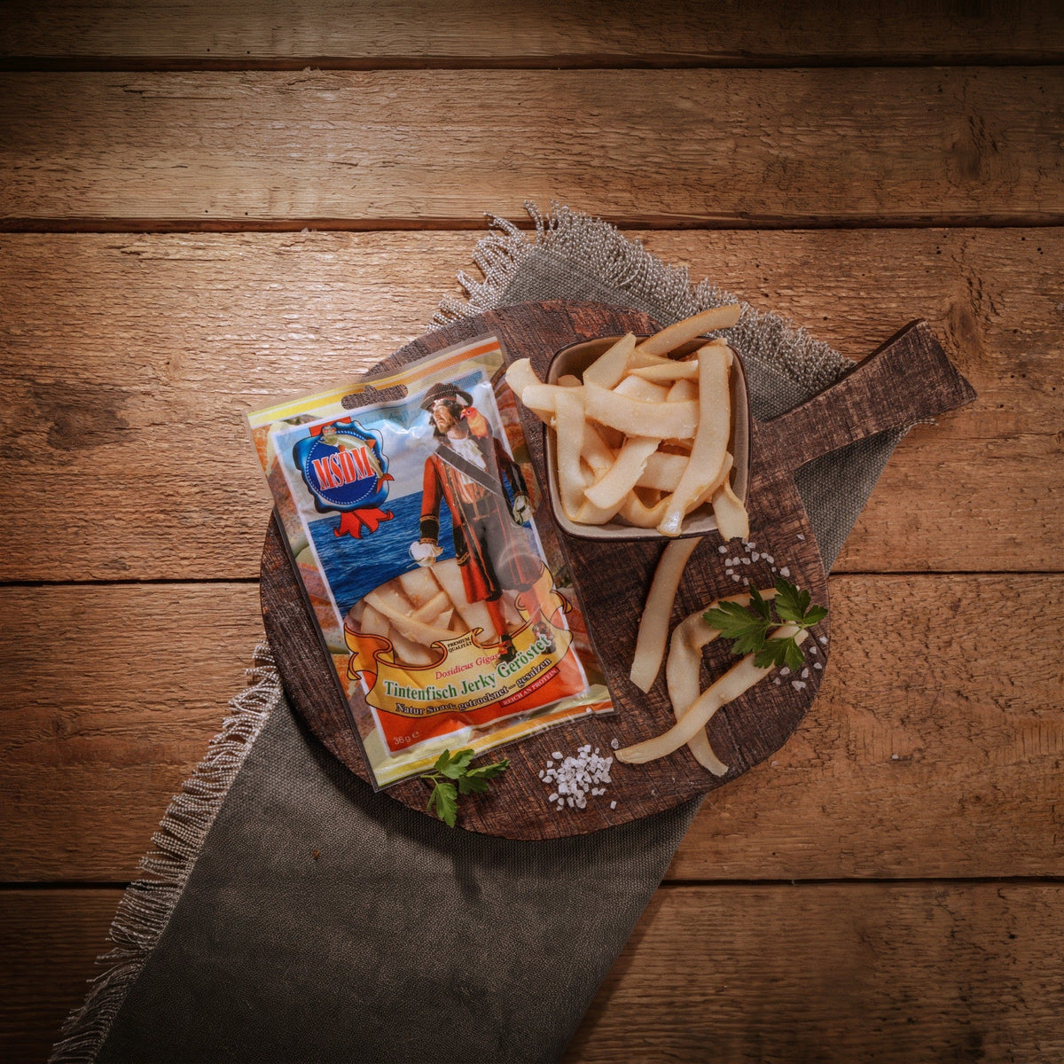 Tintenfisch Jerky Geröstet – Packung und Snack auf dem Holztisch