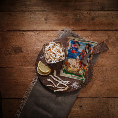 Tintenfischstreifen Original – Packung und Snack auf dem Holztisch